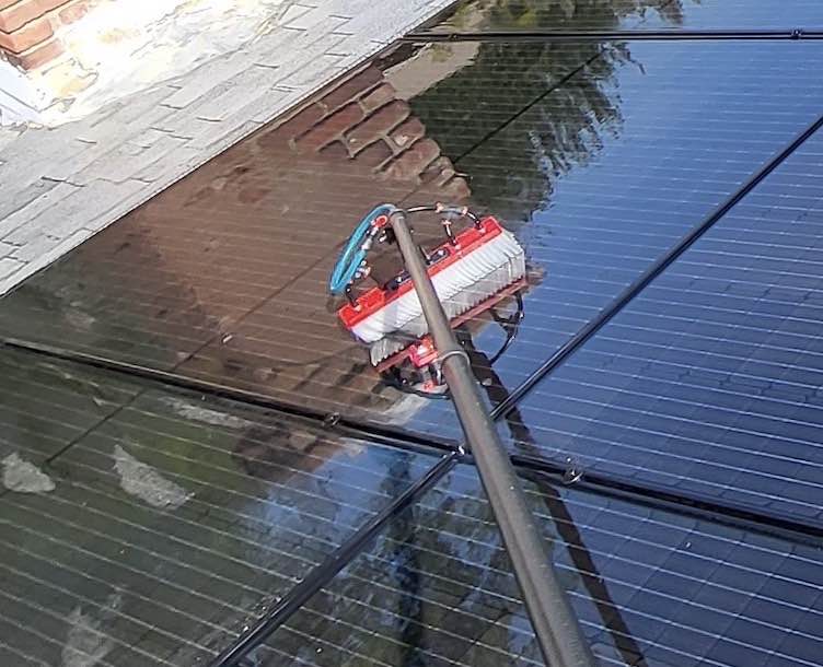 Brush and water spray to clean solar panels